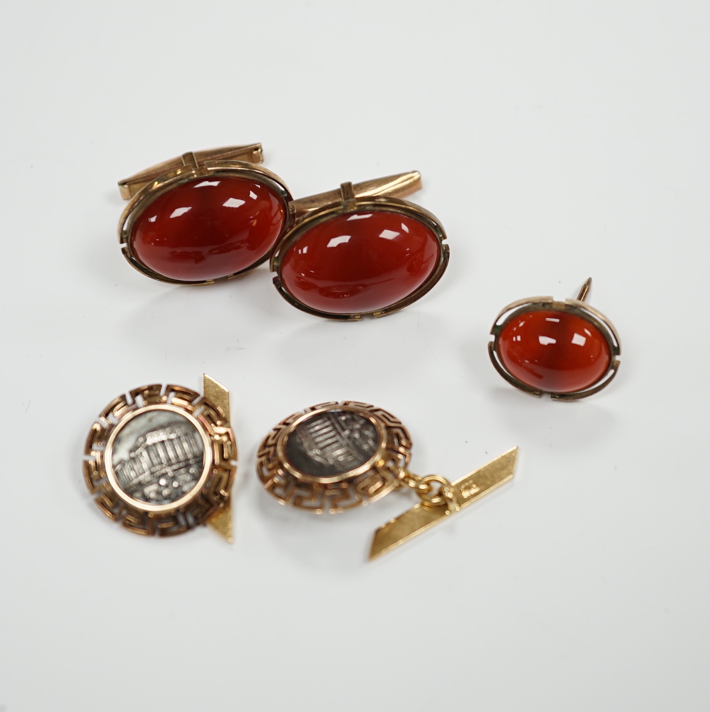 A pair of 18k and white metal 'Parthenon' circular cufflinks, with Greek Key border, 17mm, gross 8.9 grams, a pair of 10k and cabochon cufflinks and an earring.